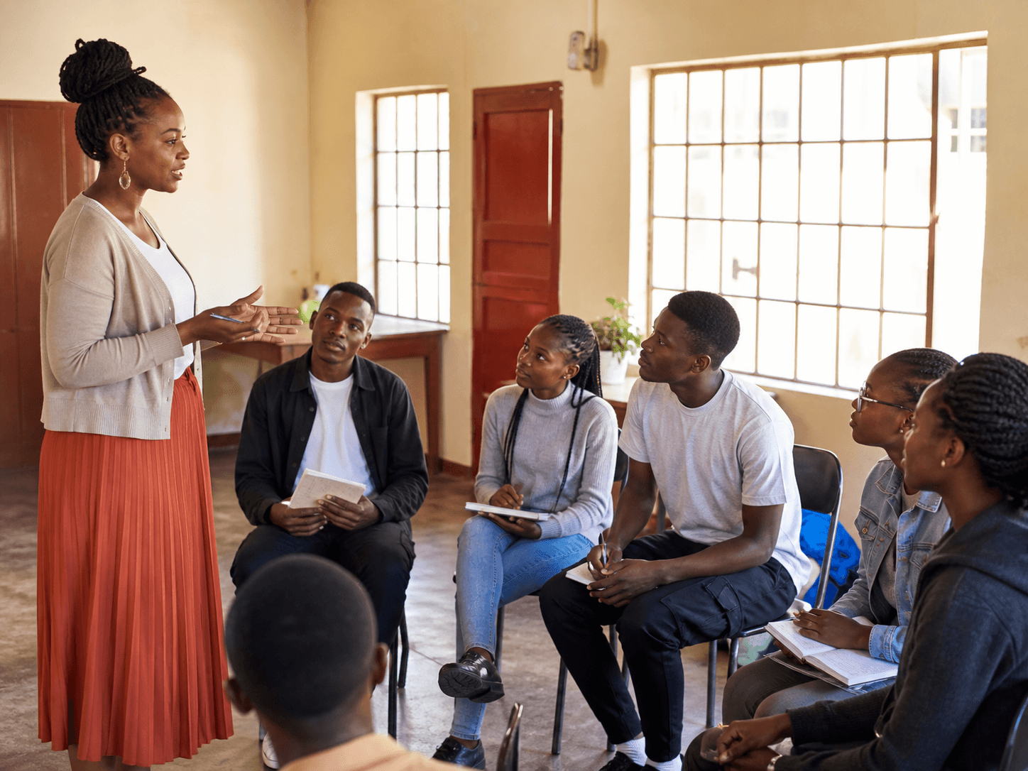 A facilitator leading a mental health awareness workshop with young adults